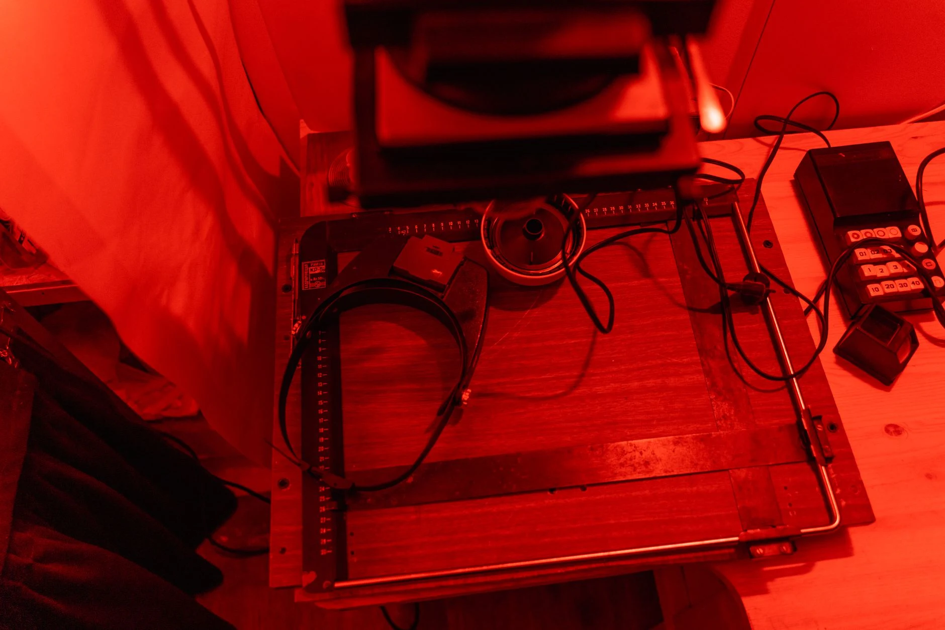 A cozy darkroom with classic film photography equipment under red lighting, evoking nostalgia.