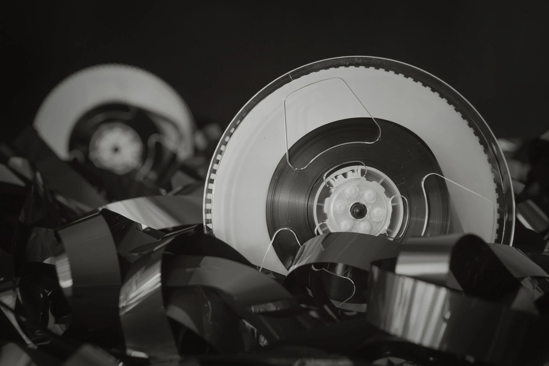 Close-up of vintage reel tape with tangled film, exuding a retro feel.