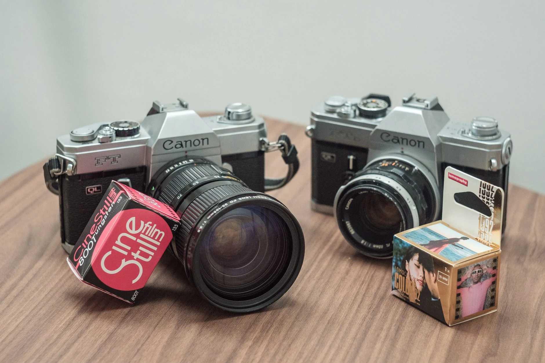Two vintage Canon cameras with CineStill film on a wooden table, perfect for retro photography enthusiasts.