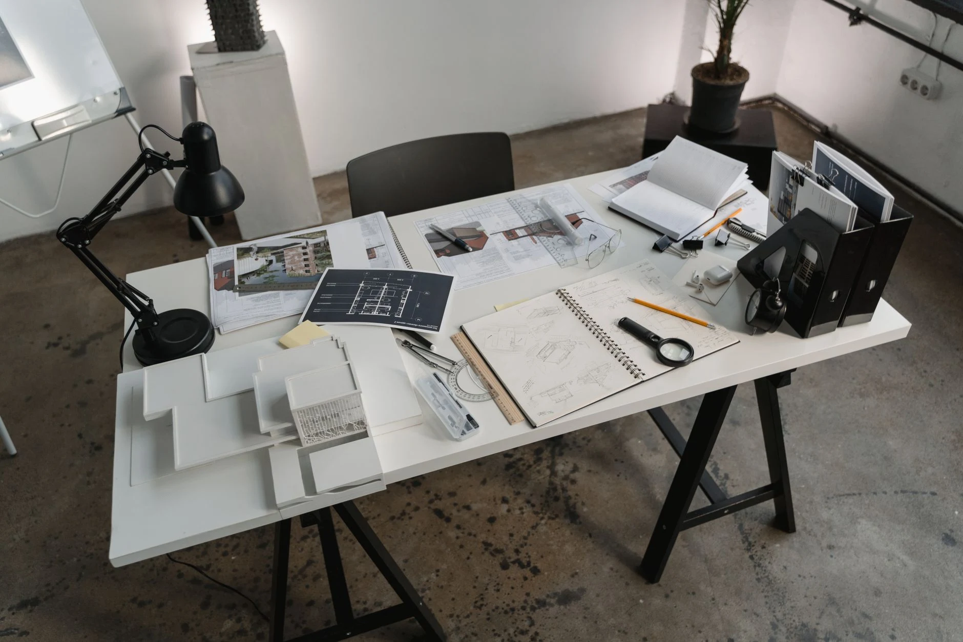 A creative workspace with architectural tools, blueprints, and sketches for design projects.