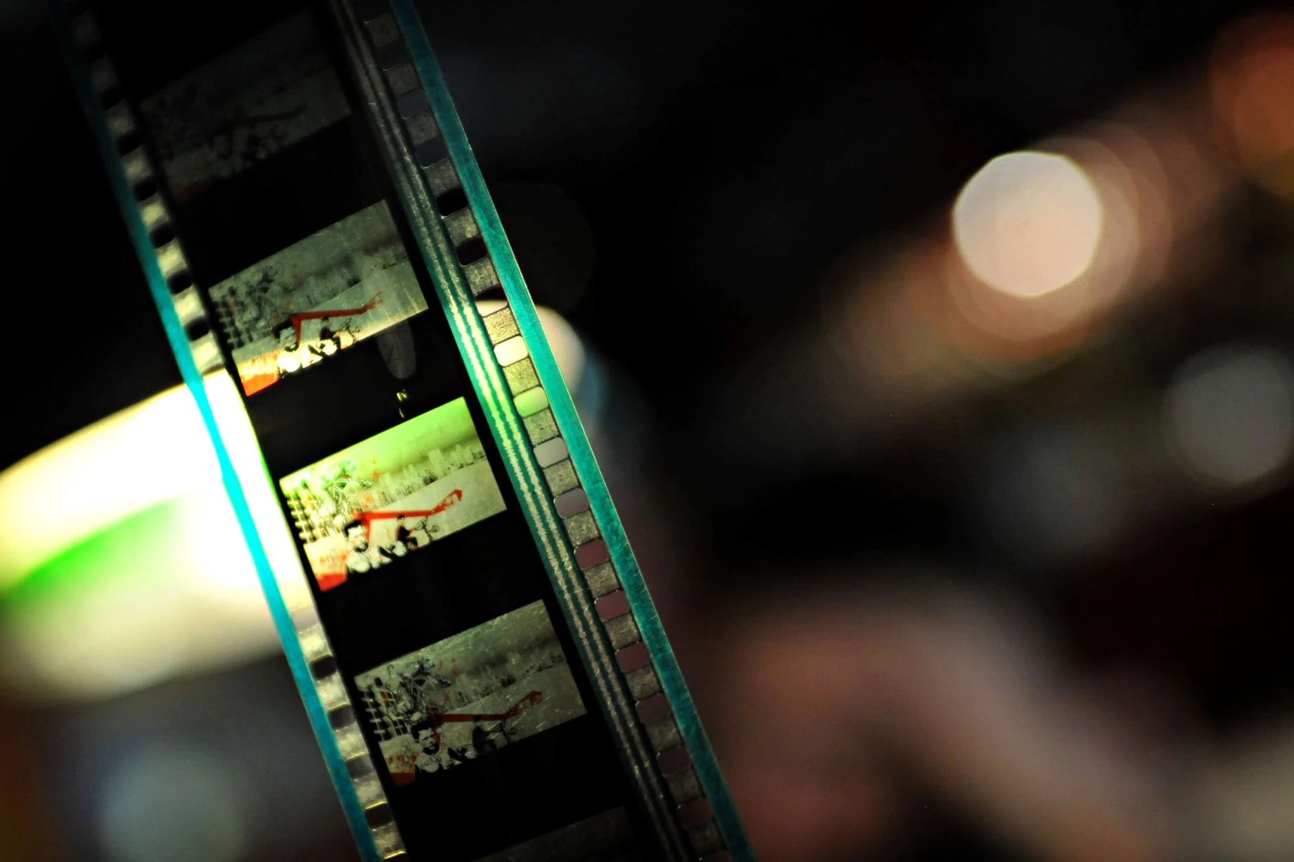 Detailed close-up of a film strip with colorful lights and soft bokeh in the background, creating a nostalgic feel.