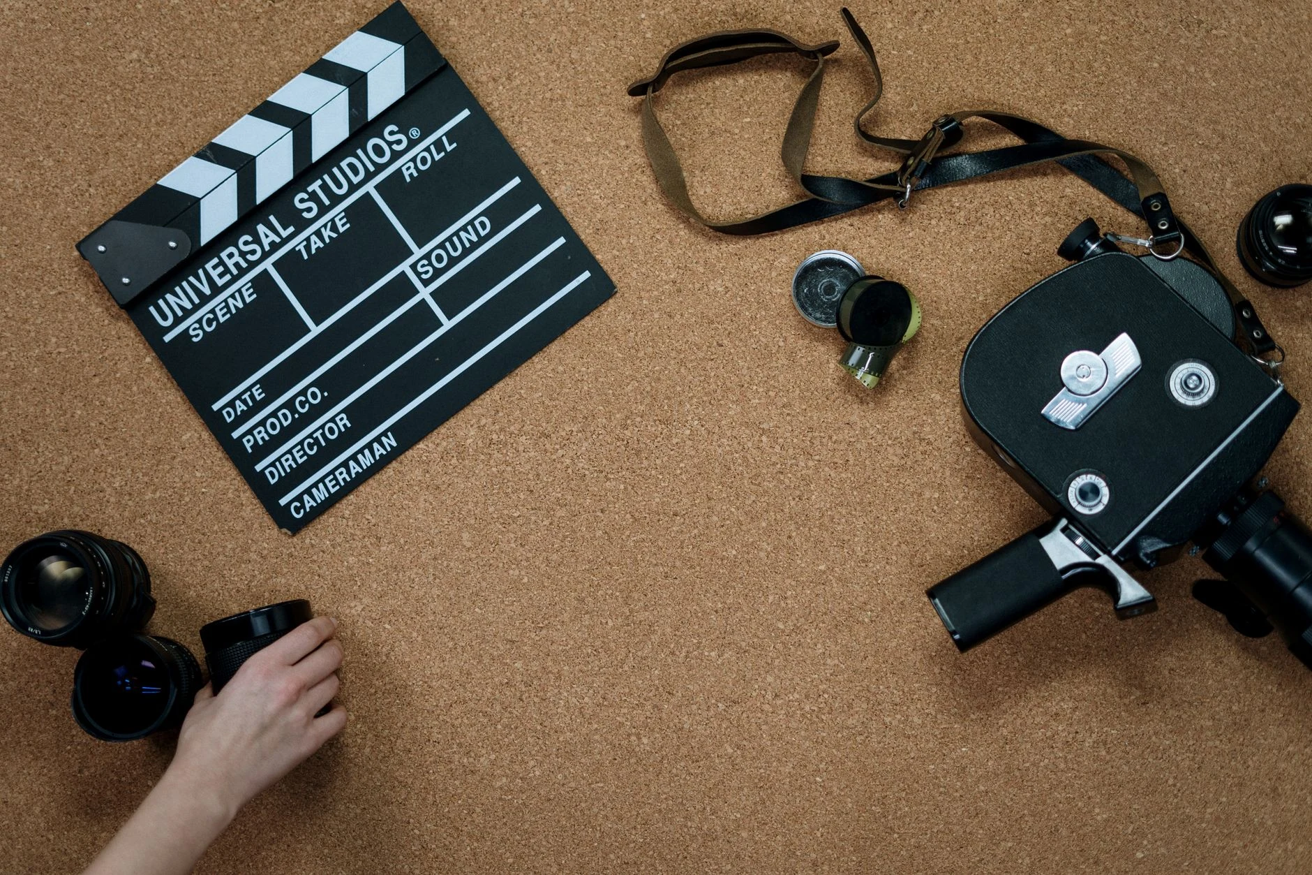 Flat lay of vintage film equipment and clapperboard on corkboard. Ideal for cinema and filmmaking concepts.