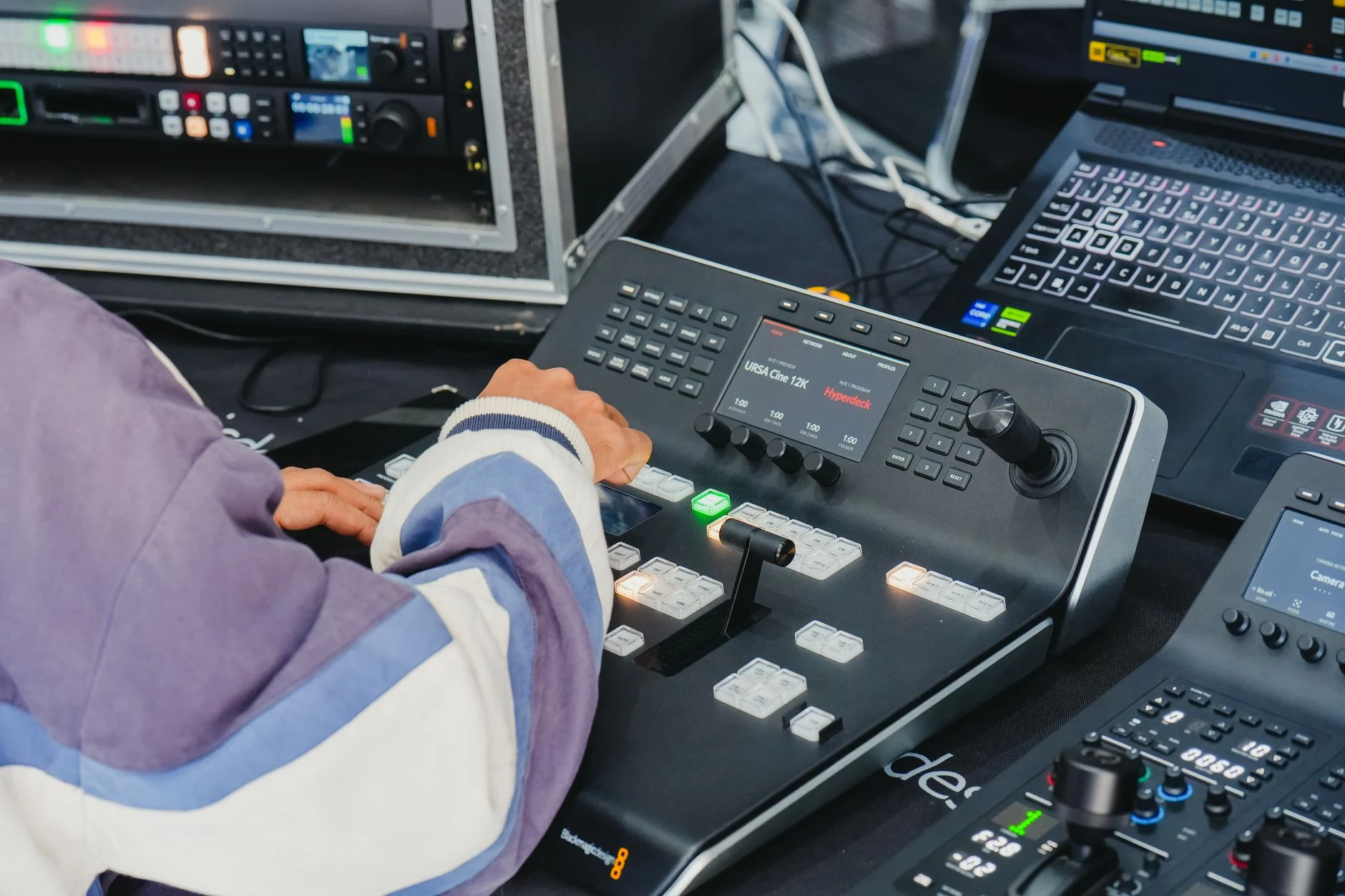 Operator managing video switcher in a professional control room with advanced equipment.